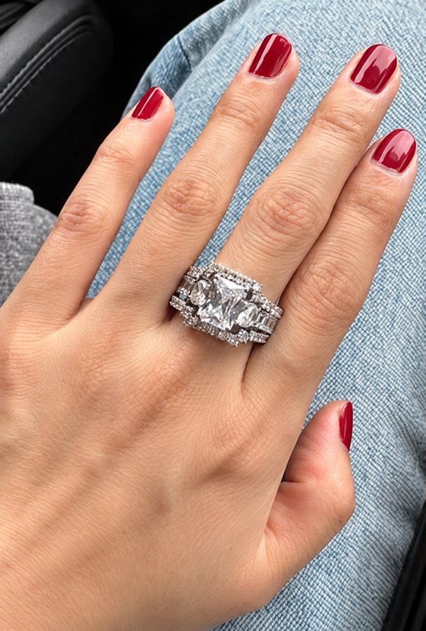 White sapphire three-piece wedding set shown on a hand from above